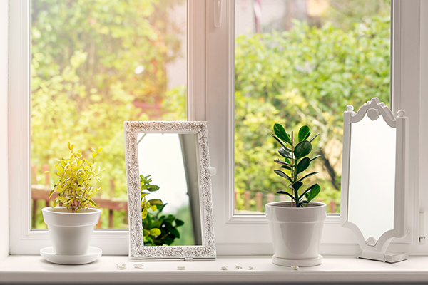 Window sill with mirrors and plants