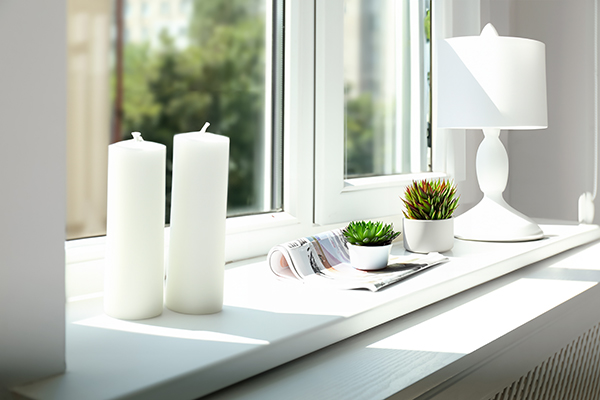 White elegant candles and lampshade window sill